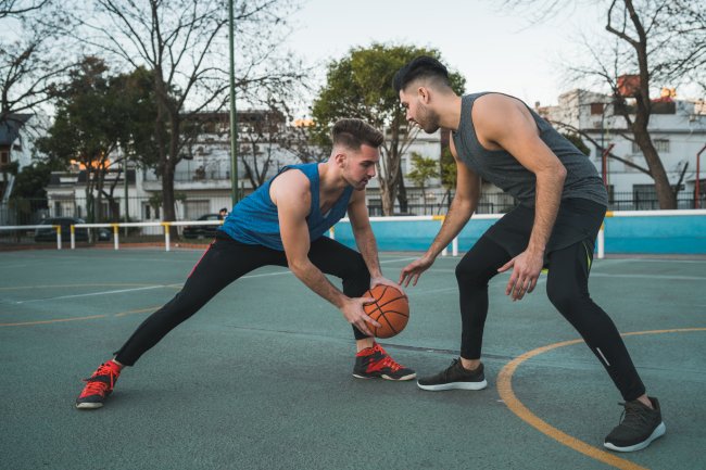 Two young friends playing basketball.